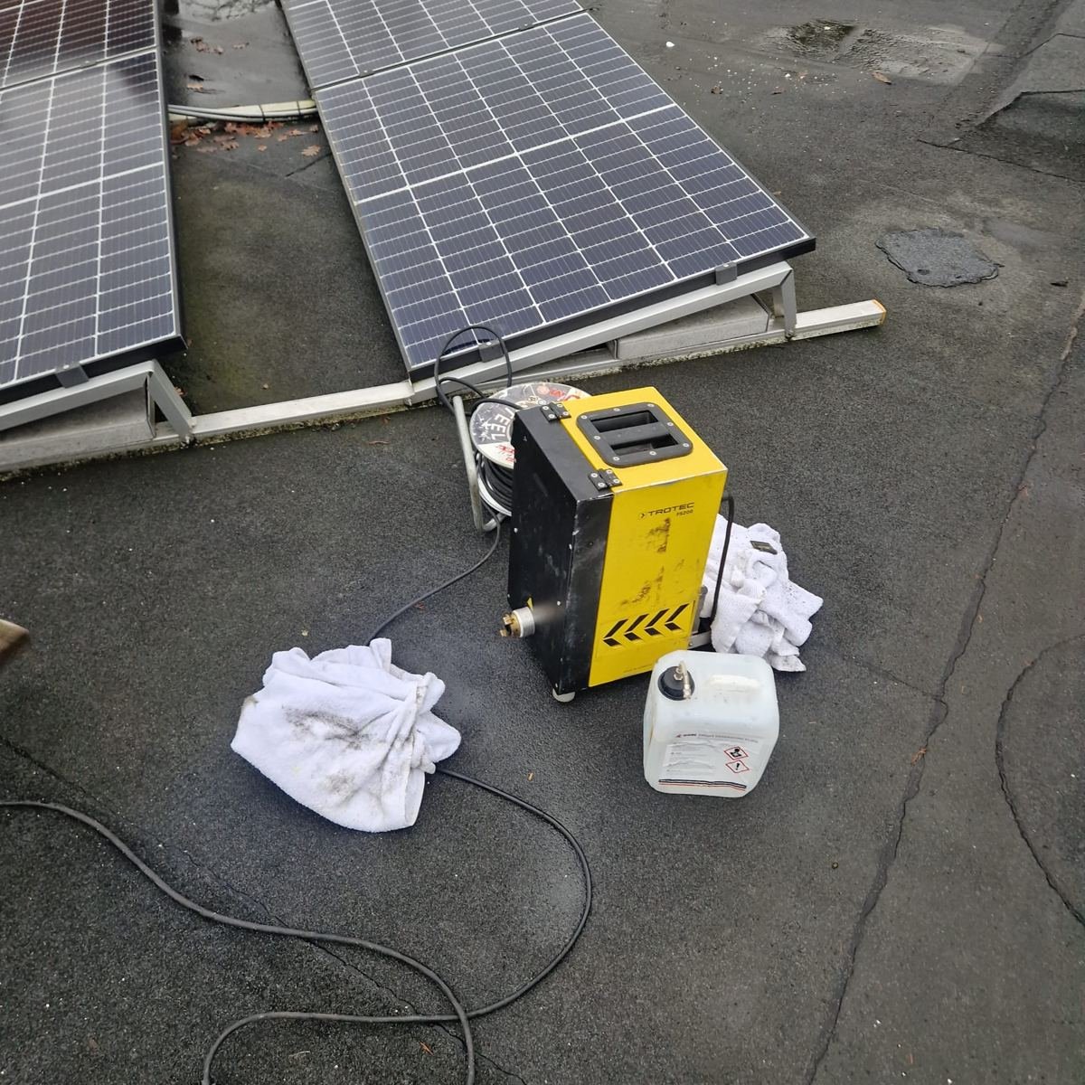 Rookmachine tijdens een rookproef op een plat dak met zonnepanelen